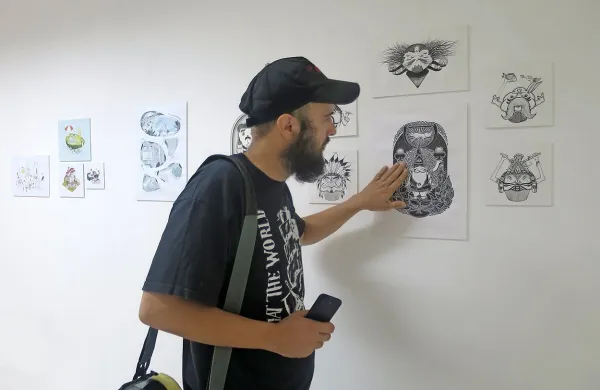 Vodja Cmakajna Matjaž Peternelj na razstavi  ilustracij Mance 
Flajs.

