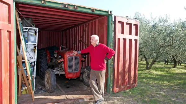 Dino Pucer pred svojim kontejnerjem, v katerem ima naprave 
in orodje za obdelovanje oljčnika.