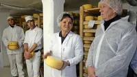 Marko Majer in Anka Lipušček Miklavič (z desne) v sušilnici  
sira Tolminca. 