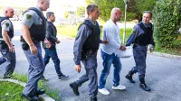  Elton Shkurti (v ozadju v temni bundi) včeraj ni hotel 
sodelovati na glavni obravnavi, tako je Valon Hoxhaj (v beli 
majici) ostal sam na zatožni klopi.  