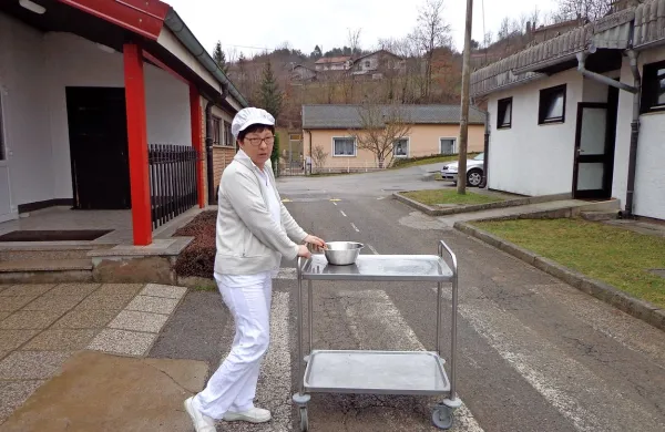 Tako kuharice trikrat na dan v vseh vremenskih razmerah z 
vozičkom prevažajo hrano iz kuhinje čez cesto v drugo 
stavbo, kjer je razdelilna kuhinja z jedilnico.