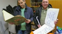 Matjaž in Konrad (z leve) ob dragocenih pustnih knjigah, ki jih 
v vasi vodijo vse od začetka 60. let.