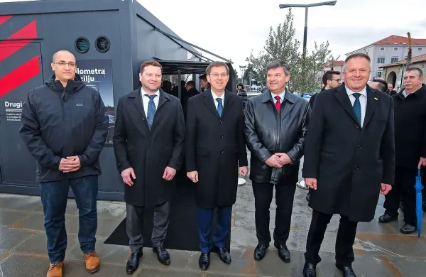 Državni sekretar na ministrstvu za infrastrukturo Jure Leben, 
koprski podžupan Peter Bolčič, Miro Cerar, minister za infrastrukturo Peter Gašperšič in minister za gospodarstvo Zdravko 
Počivalšek ob kontejnerju z maketo drugega tira. Maketa je stala 
približno 100.000 evrov. 
