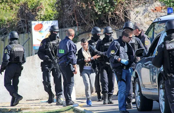 Eltona Shkurtija so  zamaskirani specialci in kriminalisti prve dni 
oktobra leta 2016 aretirali pri izolski pasji plaži  in ga pri tem  
poškodovali. Pred tem je v morje odvrgel  pištolo in rjav zavoj.