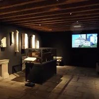 Lapidarij v župnijskem muzeju: v  ospredju je  lesen model cerkve iz 16. stoletja, desno zadaj poteka 
video prezentacija, levo  je ograja,   del obhajilne mize, ki so ga kasneje   uporabili za ograjo pred 
krstilnico,   ob njeni obnovi  pa  dali v muzej.          