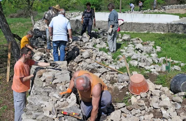 Vaščani so s pomočjo Partnerstva kraške suhozidne gradnje 
obnovili del zidu ob kalu.