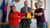 Petra Žele Šajn iz Rdečega križa je defibrilator izročila županu 
Robertu Smrdelju, on pa predsedniku vaške skupnosti Selce 
Simonu Ostanku (desno). 