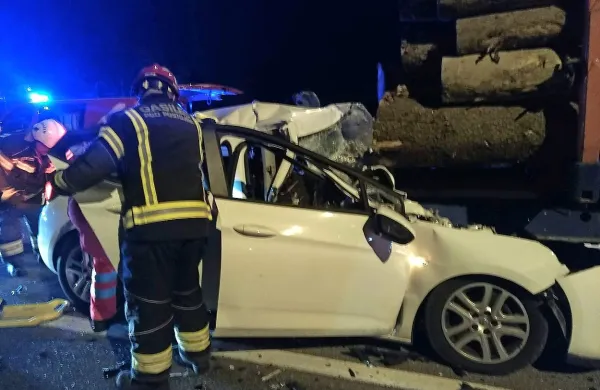 Mladi voznik se je z avtom brez zaviranja zaletel v zadnji del 
priklopnika, naloženega s hlodi. 