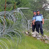 Policista Robert Brozina (desno) in Primož Brolih si ogledujeta mejo ob cesti med Sušakom in Liscem. 

