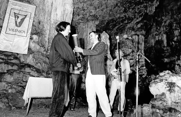 Tako je  na drugem festivalu Vilenica leta 1987 v edinstvenem 
jamskem okolju predsednik Društva slovenskih pisateljev Rudi 
Šeligo izročil nagrado avstrijskemu pisatelju Petru Handkeju.  