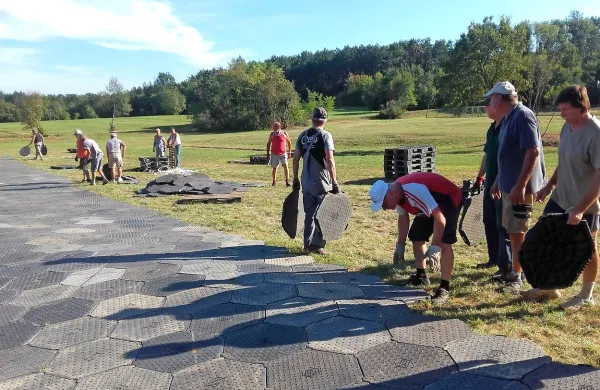 Prostovoljci, večinoma domačini, ki pripravljajo prizorišče proslave, bodo za obiskovalce pripravili “tlakovano” površino, nanjo 
pa postavili 800 stolov. Travnik so “tlakovali” s 1300 plastičnimi 
kosi.