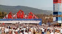 Proslava v Komnu leta 1978: oder, odet v modro barvo, za njim 
Triglav iz zastav, na desni stolp z napisom 1943-78 in sliko Tita.