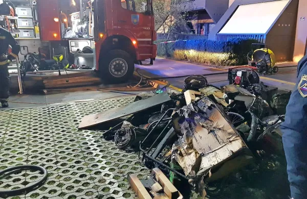 Gasilci so iz kleti pred blok prinesli uničene stvari. 