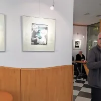 Simon Kovačič v  galeriji Pecivo, kjer so razobešene črno-bele 
fotografije ustanovitelja kluba Milenka Pegana. 