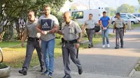 

Miroslav R. (spredaj) in Jovan P.  (zadaj med pravosodnima 
policistoma) sta na sojenju  naštevala pravice, ki so jima bile 
kršene ob prijetju in na zaslišanju.