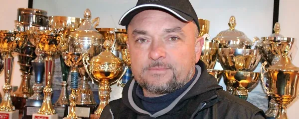 Darko Peljhan pred glavnim delom zbirke pokalov. Največje  
dirkalne in poslovne uspehe je dosegel s volkswagnovimi avtomobili. 
