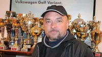 Darko Peljhan pred glavnim delom zbirke pokalov. Največje  
dirkalne in poslovne uspehe je dosegel s volkswagnovimi avtomobili. 