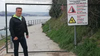 Egon Štibilj, poveljnik piranske CZ, pred ograjo, ki je preprečevala dostop do poti pod klifom, dokler neznanci žic niso preščipnili. 