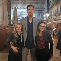 Tanja Saksida (levo) in Vesna Kristančič iz kleti Movia v čvrstem objemu 
nekdanjega košarkarja Primoža Brezca, ki je bil s prijatelji na Vinitaly. 