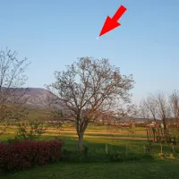 Pozno popoldansko nebo z luno (označeno s puščico) ...