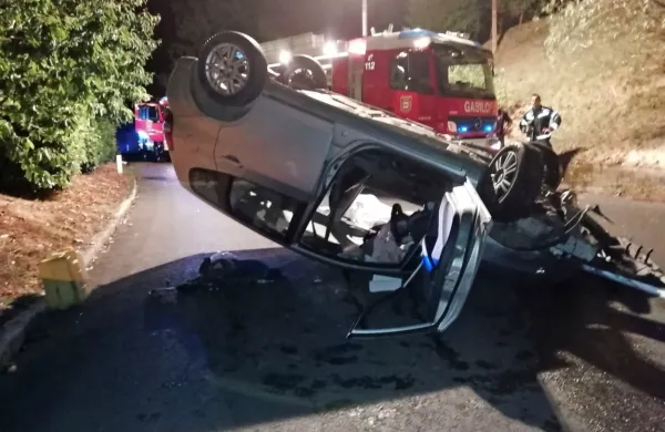 Srebrna honda jazz se je po trku v obcestni zid  odbila v desno in 
se prevrnila na streho. 