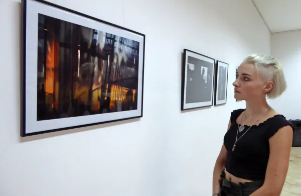 Eva Tisnikar pred eno svojih bolj barvitih fotografij, na kateri   je  poleg črne barve videti  tudi 
oranžno-rumene in modro-sive odtenke.