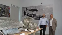 Vodja arheološkega izkopavanja Andrej Gaspari in vodja PVZ 
Janko Boštjančič ob razbitinah znamenitega letala Spitfire, ki so 
najnovejša pridobitev parka. 