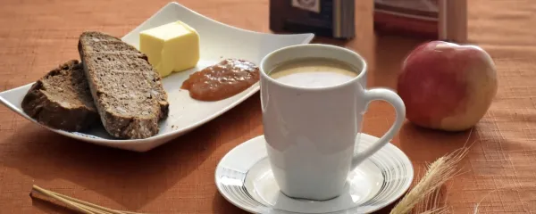 Polnozrnat kruh z maslom in marmelado, skodelica bele kave in 
jabolko -  idealna kombinacija za uspešen začetek dneva. 