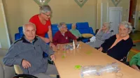 Albert Trojer (levo) se  v dnevnem varovanju odlično počuti, v 
dopoldanskem času ni več sam doma. Za varovance skrbi Mojca 
Rejc (stoji). 