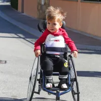 S kakšnim veseljem sede Kris v svoj mali invalidski voziček, ki mu omogoča, da 
se lahko samostojno premika!  “Ko smo  ga prvič posedli vanj, je takoj razumel, 
da mora poganjati kolesa, če se želi premikati,”  ponosno pove tata Matteo. 