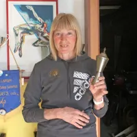 Lidija Kristančič v svoji spominski sobi. Levo je priznanje za 
jugoslovansko atletinjo leta 1983, v roki pa drži priznanje za 
najboljšo športnico Osnovne šole Dobrovo. 