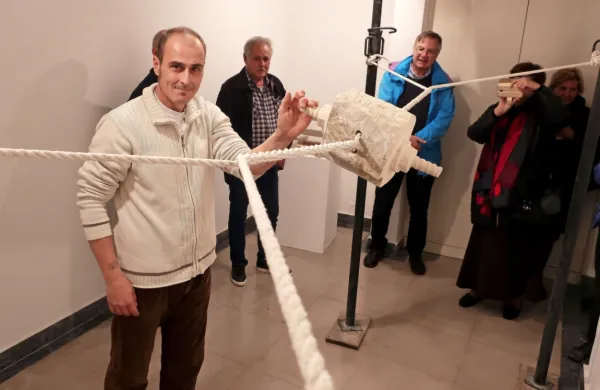 Kipar Miha Pečar ob skulpturi na vrveh: počasi jo navije  obiskovalec, hitro se odvije sama.  