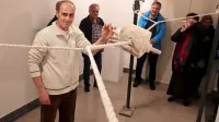Kipar Miha Pečar ob skulpturi na vrveh: počasi jo navije  obiskovalec, hitro se odvije sama.  