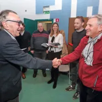 Pisatelj Milan Rakovac (levo) in predsednik openske sekcije 
Vsedržavnega združenja partizanov Italije Duško Kalc. V ozadju (z 
leve) poveljnik državne enote za varstvo pred NUS Darko Zonjič, 
voditeljica Karin Sabadin in predsednik KS Jagodje-Dobrava 
Matjaž Gergeta. 
