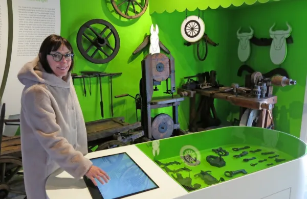 Tina Novak Pucer v prostoru, ki je nekoč služil kot depo, zdaj pa tam domuje razstava Od kovača do kolarja.