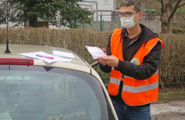Prostovoljec Drejc Kokošar med raznašanjem te dni najredkejše 
dobrine - zaščitnih mask. 