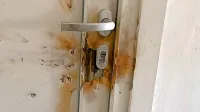 Posledice, ki jih je petarda pustila na sosedovih vratih.