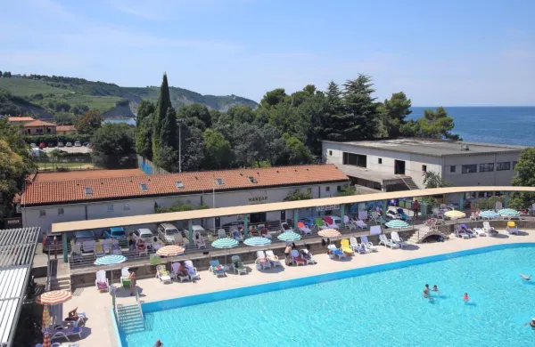 Od Hotela Delfin je poslej tudi zemljišče nasproti zunanjega bazena, kjer sta Hangar bar  in nekdanji veslaški hangar pa tudi sanitarije 
marine (desno).