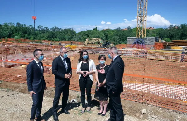 V ozadju zametki  garaže  centra odličnosti InnoRenew CoE, v 
ospredju (z leve): izolski poslanec Gregor Perič (SMC) in župan 
Danilo Markočič, ministrica Simona Kustec, direktorica Andreja 
Kutnar  in minister Zdravko Počivalšek 