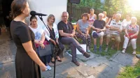 Maša Budič med pripovedovanjem, ob njej sedita  pisateljici Mateja Perpar in Natalija Šimunović. 