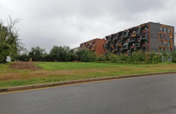 Nov neprofitni blok, še zadnji na tem     območju, bo zrasel na 
zelenici v ospredju  fotografije in vzdolž ceste.  