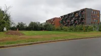Nov neprofitni blok, še zadnji na tem     območju, bo zrasel na 
zelenici v ospredju  fotografije in vzdolž ceste.  