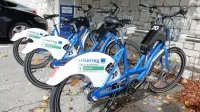  Na Krasu in v Brkinih si je možno brezplačno izposoditi električna 
kolesa (na fotografiji je postaja pri osnovni šoli v Sežani), vendar je 
v primeru okvar vzdrževalec dokaj slabo odziven.