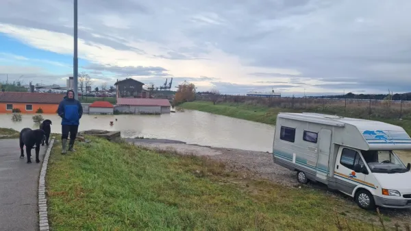 Družina Atlija je morala svojo “potopljeno”  hišo (v ozadju) začasno 
zamenjati za avtodom.