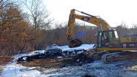 S plastično folijo in snegom prekrito odpadno blato so včeraj zjutraj tako začeli nakladati na tovornjake in voziti v Ljubljano.