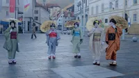 Japonske gejše, ki jih je živo srebro pripeljalo v Idrijo, na praznem 
(epidemiološko ustreznem) osrednjem idrijskem trgu. 