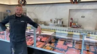 Kristjan Cerkvenik pred pultom v svoji mesnici Bišteka v Sežani