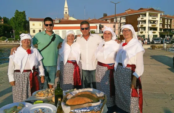 Štiri predstavnice KD Malija (z leve): Laura Babič, Nevija Šalkovič, 
Neža Molk in Jasna Cokan, vmes Matej Zaro in Dean Kocjančič iz 
Turističnega združenja Izola. Fotografija je nastala leta 2018.    