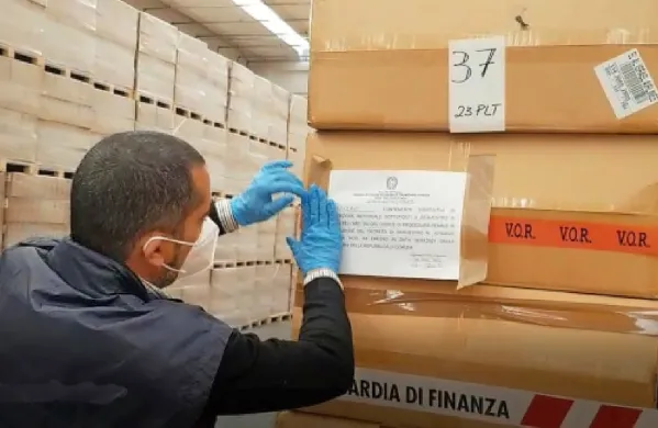 Finančni policisti med zasegom spornih mask.