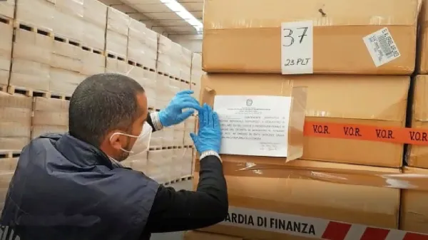 Finančni policisti med zasegom spornih mask.